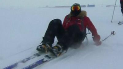 Prince Harry sits on snow in skis after falling over