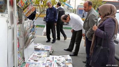 Iranians look at newspapers in Tehran