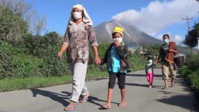 Indonesians walking away from the Mount Sinabung volcano in North Sumatra