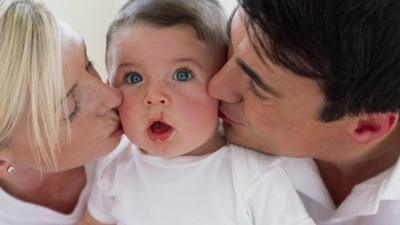 Parents kissing baby boy