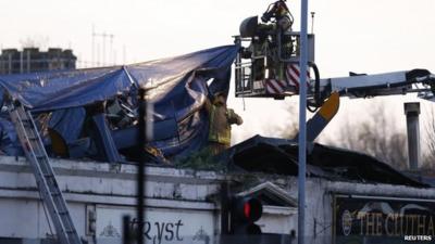 Rescue workers cover the wreckage of a police helicopter which crashed onto the roof of the Clutha Vaults pub in Glasgow