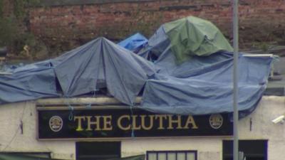 Wreckage on pub roof, covered in tarpaulin