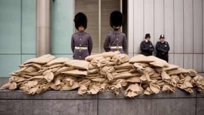 Soldiers stand guard over sacks of "sacred soil" taken from World War I battlefields