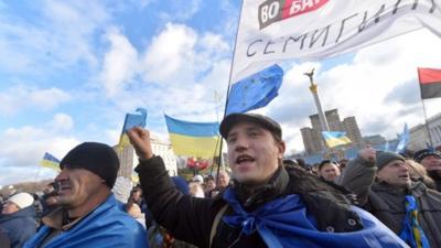 People shout slogans and wave flags of Ukraine and the European Union during a rally of the opposition on Independence Square in Kiev on December 2, 2013