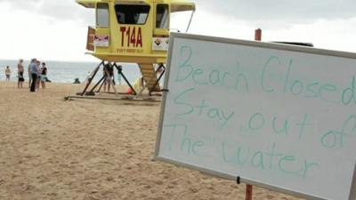 Sign on beach warning people to stay out of the water