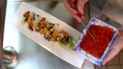 chef plating a dish including sea snails