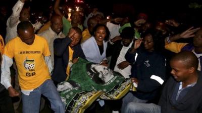 People chant slogans outside Nelson Mandela's house in Houghton