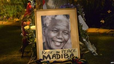 Flowers and poster reading "Rest in peace Madiba"