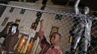 Young boy poses in front of Nelson Mandela statue