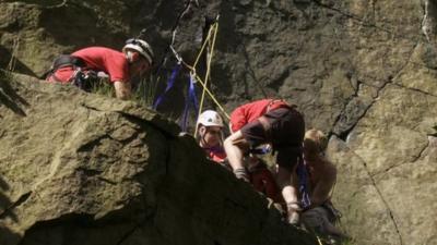 Rescue workers try to free the climber