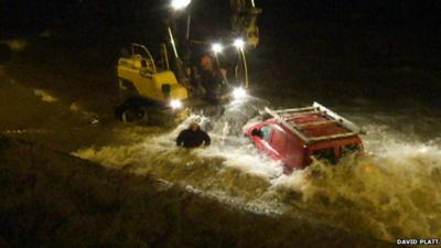 Waves crash around the van