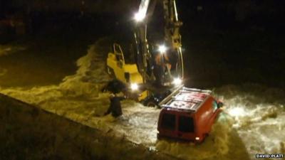 A man and a fork lift truck avoid being swept into the water while trying to recover a van