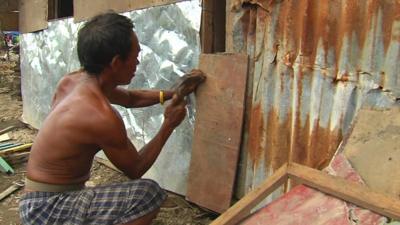 Man rebuilding hut
