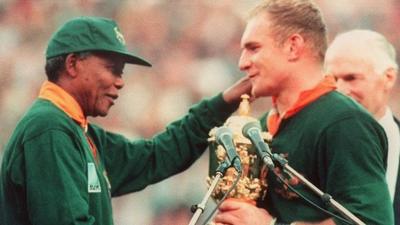 Francois Pienaar receives the Rugby World Cup from Nelson Mandela