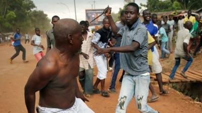 A Christian man chases a suspected Seleka officer in civilian clothes with a knife near the airport in Bangui, Central African Republic, 9 December 2013