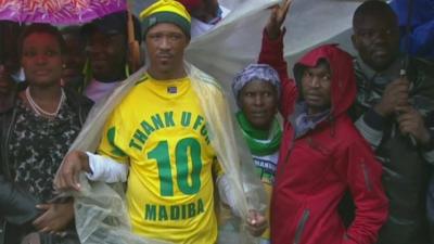 Man wearing football shirt emblazoned with "thank u for Madiba"