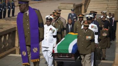 Military officers carry the coffin of former South African president Nelson Mandela into the Union Buildings in Pretoria for the three-day lying in state in Pretoria