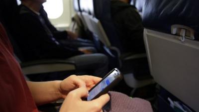 Woman uses phone on plane