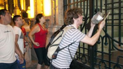 A man bangs a pot at the gates of the Government House during a protest by people demanding security and a stop to recent looting, in the northern Argentine province of Tucuman December 10, 2013.