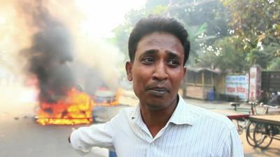 A man who's car has been torched during violent protests in Dhaka, Bangladesh