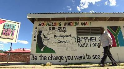 Man walking past 'Madiba wall'