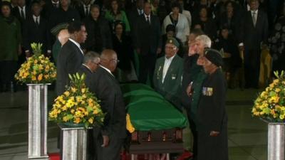 Mourners stand around the coffin of late former South African President Nelson Mandela during a send-off ceremony at Waterkloof Air Force base in Pretoria