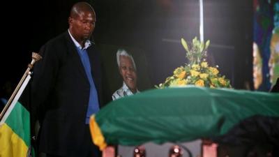 Mandla Mandela, stands next to his grandfather's coffin