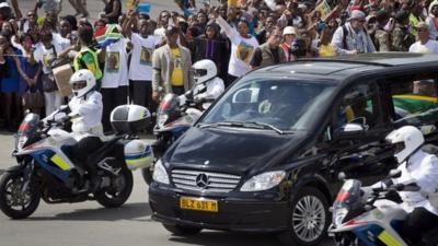 Crowds surround the hearse carrying Nelson Mandela's body