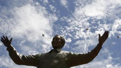 South African military jet fighters fly past a nine-metre (30ft) bronze statue of the late former South African President Nelson Mandela