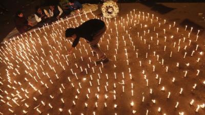 A protester lights a candle at a vigil in New Delhi