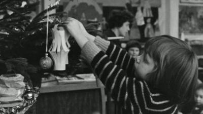 Girl putting a decoration on a Christmas tree