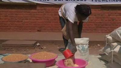 Woman measures out food into bowl