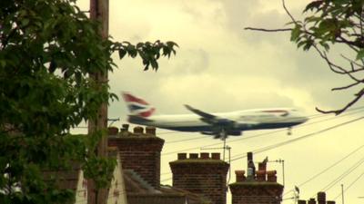 Plane flying over rooftops