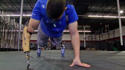 Injured US Army soldier Larkin O'Hern does push ups with prosthetic arm.