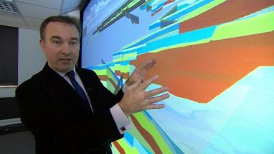 BBC reporter John Moylan beside a 3D visual representation of the geology of the UK