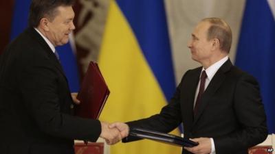 Russian President Vladimir Putin (right) and Ukrainian President Viktor Yanukovych shake hands in Moscow