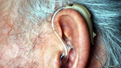 An elderly person wearing a hearing aid