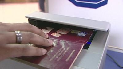 Traveller holding passport in scanner