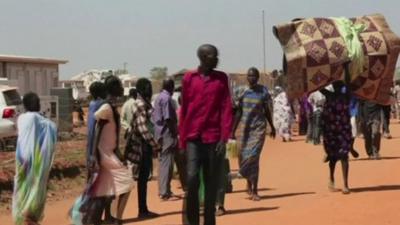 People walking in the street with their belongings