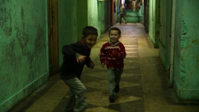 Samuel and another Roma boy play in the corridor of the derelict laboratory