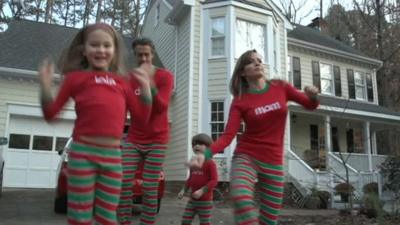 Family jumping around in Christmas pyjamas