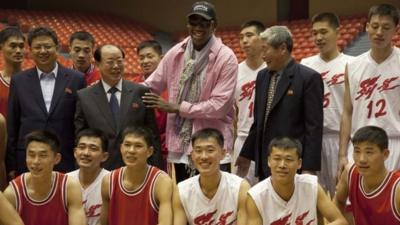 Former NBA basketball star Dennis Rodman poses for pictures with North Korean basketball players and government officials during a practice session in Pyongyang, North Korea