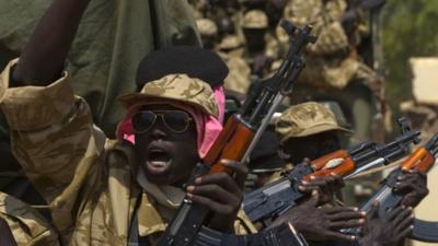 A SPLA soldier gestures as he sits in a vehicle in Juba