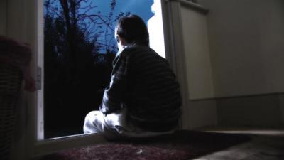 A child sitting in a doorway