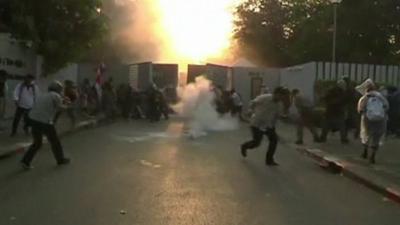 Tear gas grenade exploding in among fleeing protesters