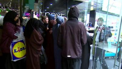 Shop staff ask crowd to hold back as doors open