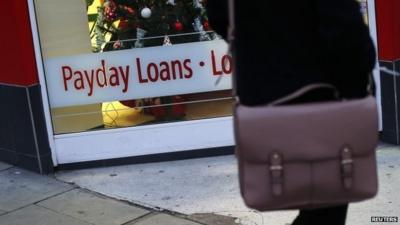 Woman walks past payday loan shop