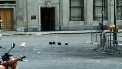 Police helmets and hats mark the spot of the fatal shooting of WPC Yvonne Fletcher outside the Libyan People's Bureau