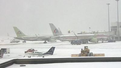 Snow plough on runway near passenger planes