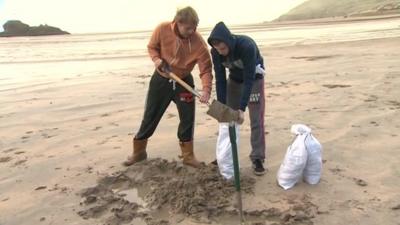 People fill sandbags on the beach at Perranporth in Cornwall